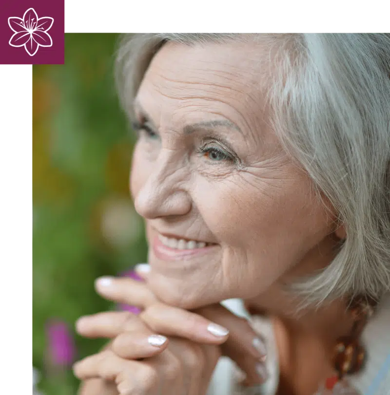 Elder woman smiling with hands under chin