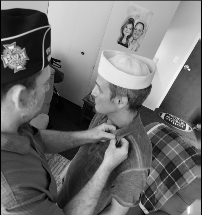 A VFW Post 6896 member pins a Navy veteran's collar during a Lily Hospice veteran pinning ceremony