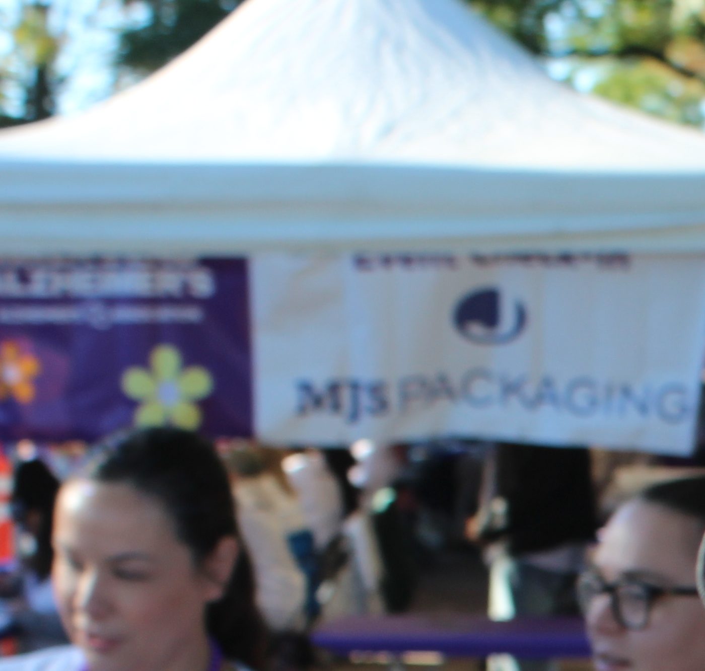 A Lily Hospice walker in purple Walk to End Alzheimer's beads and face glitter at the 2026 Detroit Walk